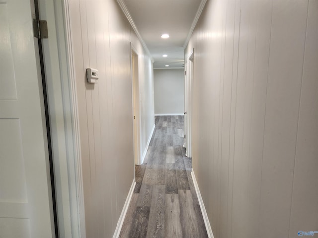 hallway featuring ornamental molding, hardwood / wood-style floors, and wooden walls