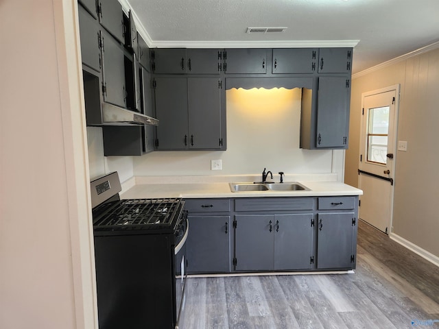 kitchen with sink, gas stove, gray cabinets, crown molding, and light wood-type flooring