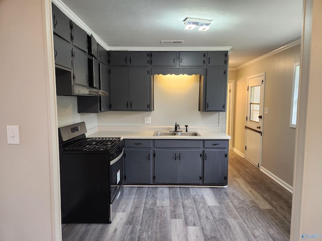 kitchen featuring stainless steel range with gas stovetop, sink, dark hardwood / wood-style floors, and crown molding