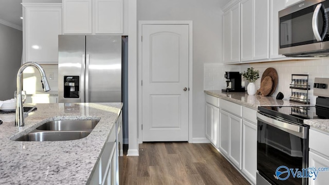 kitchen featuring sink, ornamental molding, dark hardwood / wood-style flooring, white cabinetry, and stainless steel appliances