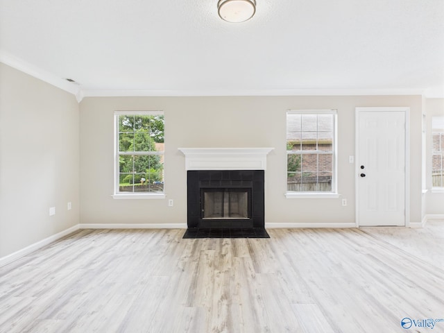 202 Declaration Cir, Madison, AL 35758 - unfurnished living room with wood finished floors, a tiled fireplace, and ornamental molding