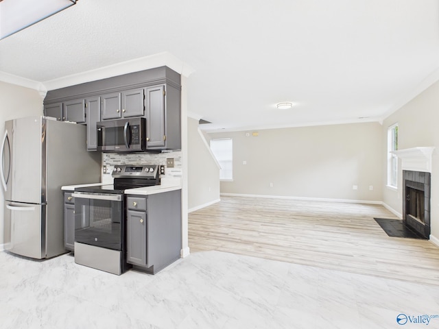 202 Declaration Cir, Madison, AL 35758 - kitchen with appliances with stainless steel finishes, ornamental molding, gray cabinetry, open floor plan, and a tiled fireplace