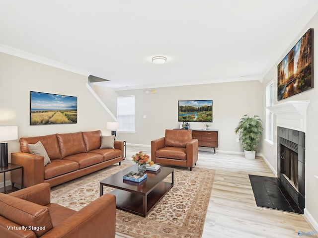 202 Declaration Cir, Madison, AL 35758 - living room featuring a tile fireplace, light wood-style floors, plenty of natural light, and ornamental molding