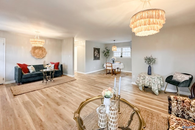 living area featuring a notable chandelier, baseboards, and wood finished floors