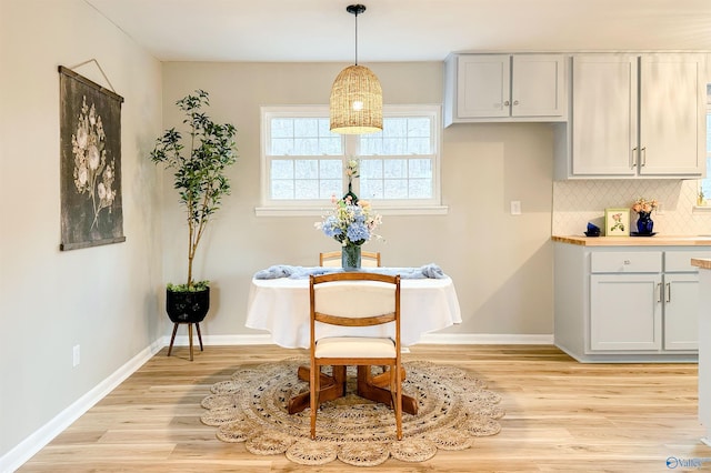 living area featuring baseboards and light wood-type flooring