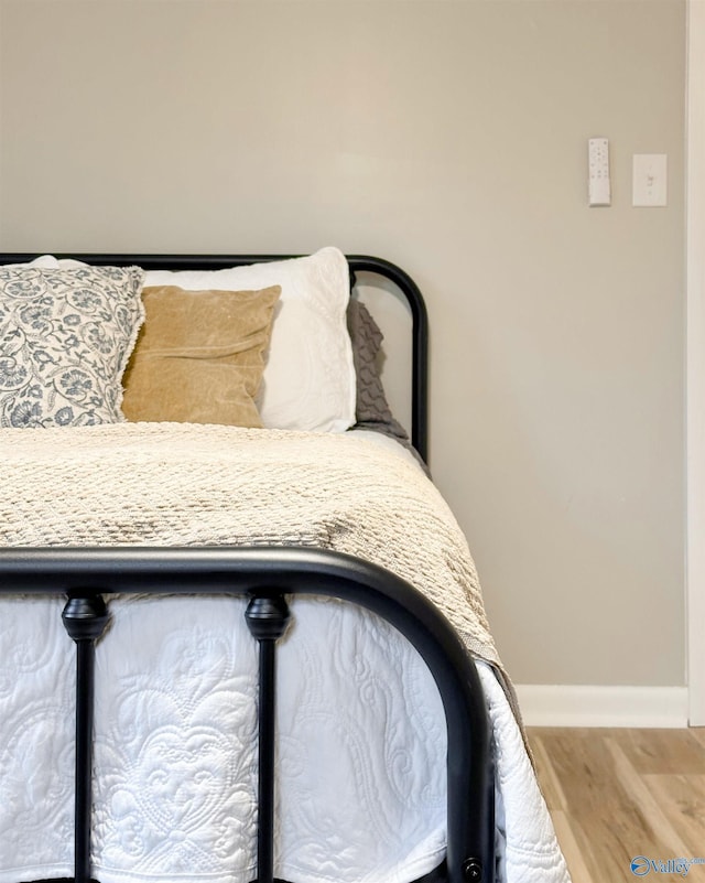 bedroom featuring wood finished floors and baseboards