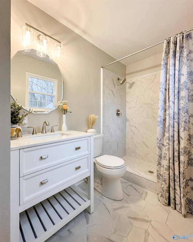 bathroom featuring vanity, toilet, marble finish floor, and tiled shower