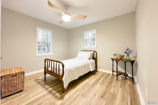 bedroom featuring a ceiling fan, baseboards, and light wood finished floors