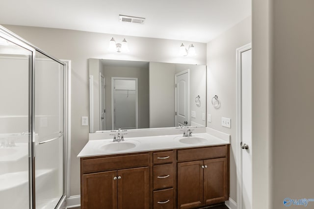 bathroom with a sink, visible vents, double vanity, and a stall shower