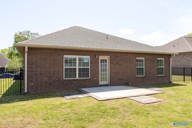 back of property featuring a patio area, fence, brick siding, and a lawn
