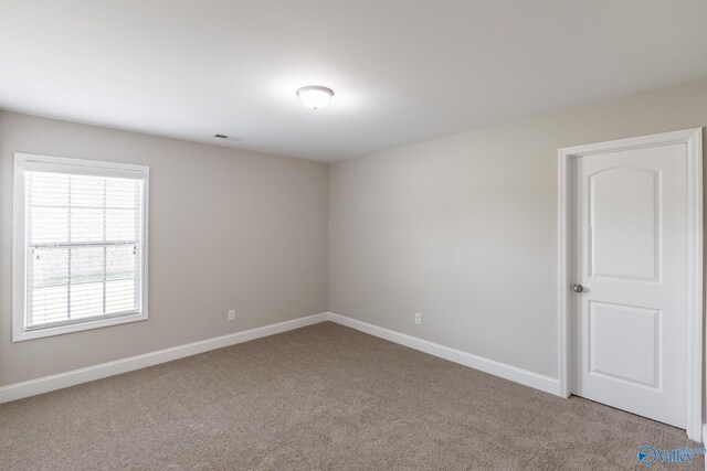 unfurnished room featuring visible vents, baseboards, and light carpet