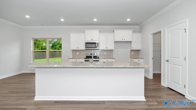 kitchen featuring white cabinetry, stainless steel appliances, a kitchen island with sink, and light stone counters