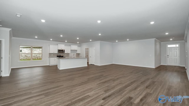 unfurnished living room with ornamental molding and dark hardwood / wood-style floors