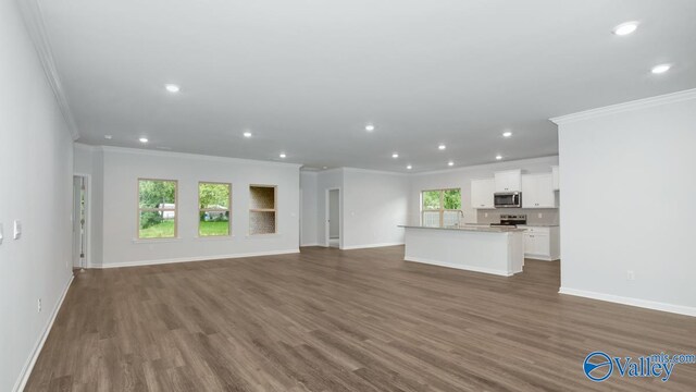 unfurnished living room with dark wood-type flooring and crown molding