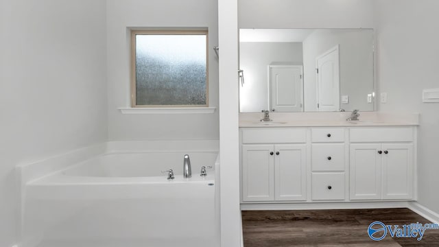 bathroom featuring vanity, a bathing tub, and hardwood / wood-style floors