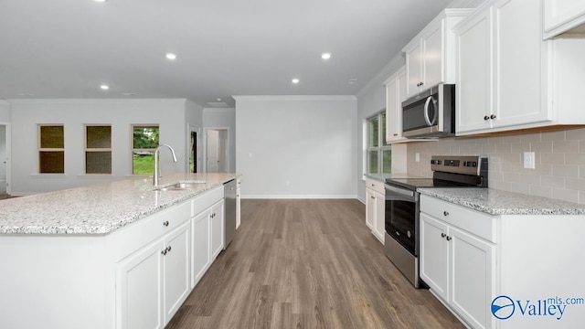 kitchen featuring sink, white cabinetry, stainless steel appliances, light stone countertops, and a kitchen island with sink