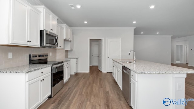 kitchen featuring sink, stainless steel appliances, an island with sink, and white cabinets