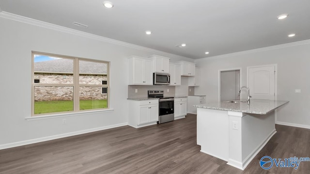 kitchen with appliances with stainless steel finishes, white cabinetry, sink, light stone countertops, and a center island with sink