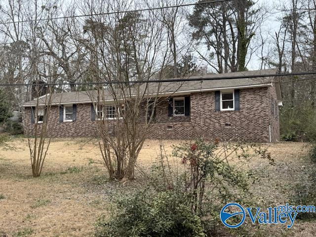 view of front of property with brick siding and crawl space