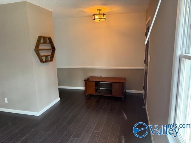 2500 Montezuma Dr, Gadsden, AL 35904 - spare room featuring a textured ceiling, dark wood-type flooring, and baseboards