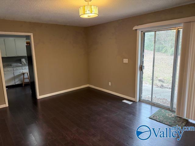 2500 Montezuma Dr, Gadsden, AL 35904 - spare room featuring dark wood finished floors, a textured ceiling, and baseboards