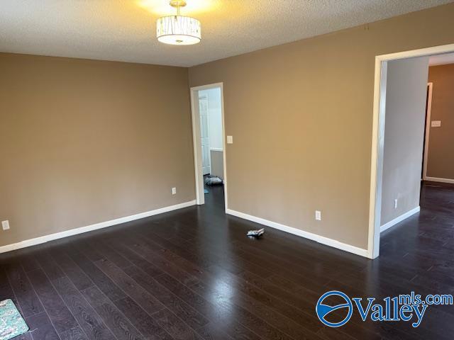 2500 Montezuma Dr, Gadsden, AL 35904 - unfurnished room with dark wood finished floors, a textured ceiling, and baseboards