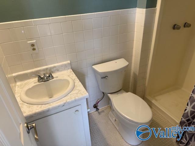 2500 Montezuma Dr, Gadsden, AL 35904 - full bathroom with tile walls, toilet, vanity, a shower stall, and tile patterned flooring