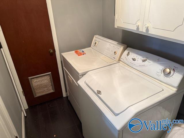 2500 Montezuma Dr, Gadsden, AL 35904 - clothes washing area featuring dark wood-type flooring, cabinet space, visible vents, and washer and dryer