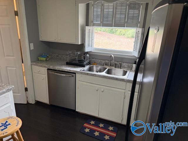 2500 Montezuma Dr, Gadsden, AL 35904 - kitchen with white cabinets, dark wood finished floors, stainless steel appliances, light countertops, and a sink