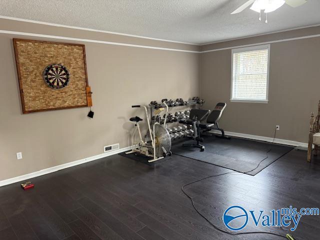 2500 Montezuma Dr, Gadsden, AL 35904 - exercise room with baseboards, visible vents, ceiling fan, wood finished floors, and a textured ceiling