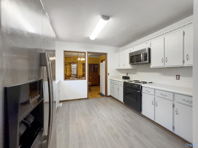 kitchen with stainless steel appliances, white cabinetry, light hardwood / wood-style floors, and a textured ceiling