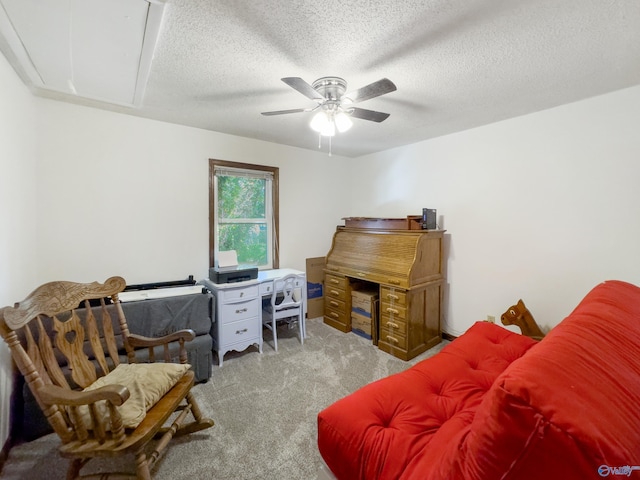 office featuring ceiling fan, light colored carpet, and a textured ceiling