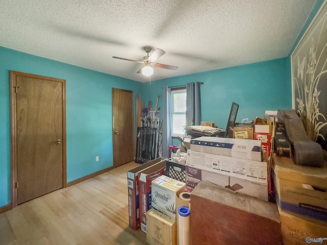 bedroom featuring light wood-type flooring, ceiling fan, and a textured ceiling