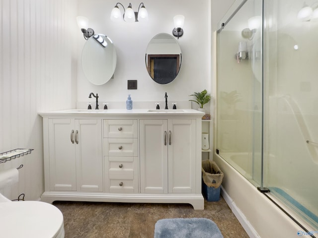 full bathroom with enclosed tub / shower combo, vanity, and toilet