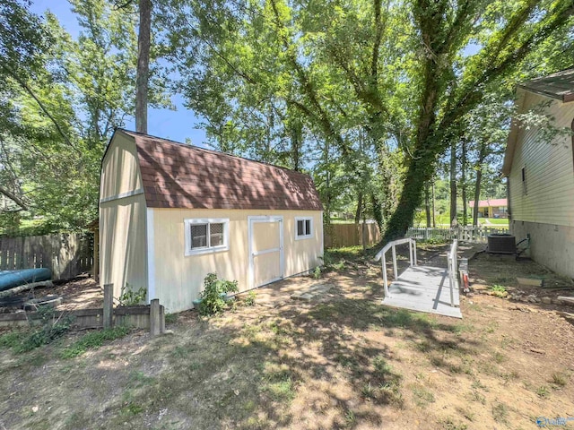 exterior space featuring cooling unit and a storage shed