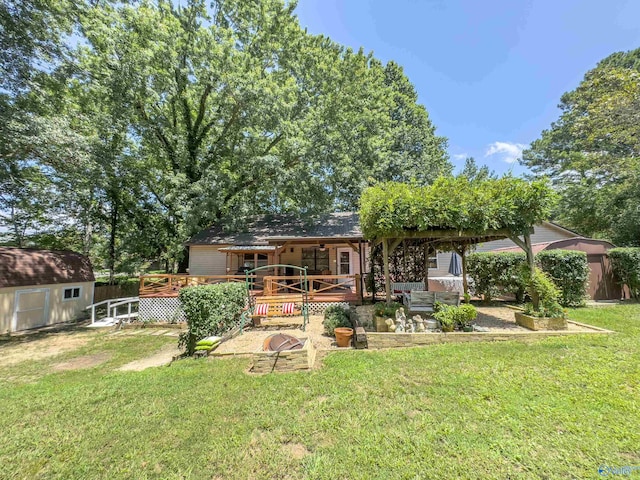 back of property with a shed, a lawn, and a wooden deck