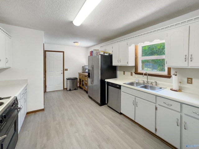 kitchen featuring white cabinets, sink, a textured ceiling, appliances with stainless steel finishes, and light wood-type flooring