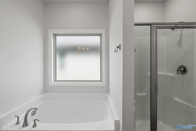 bathroom featuring shower with separate bathtub