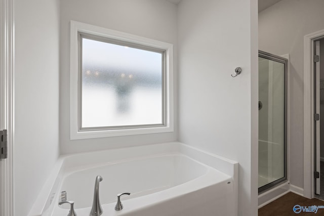 bathroom featuring separate shower and tub and a healthy amount of sunlight