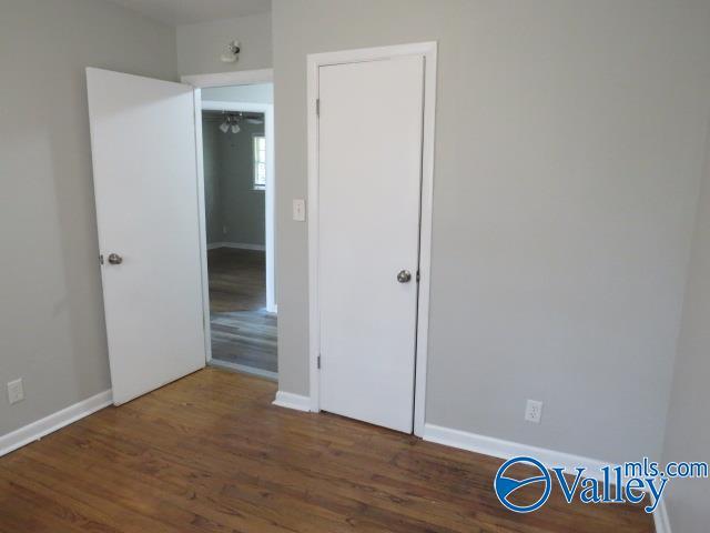 unfurnished bedroom with baseboards and wood finished floors