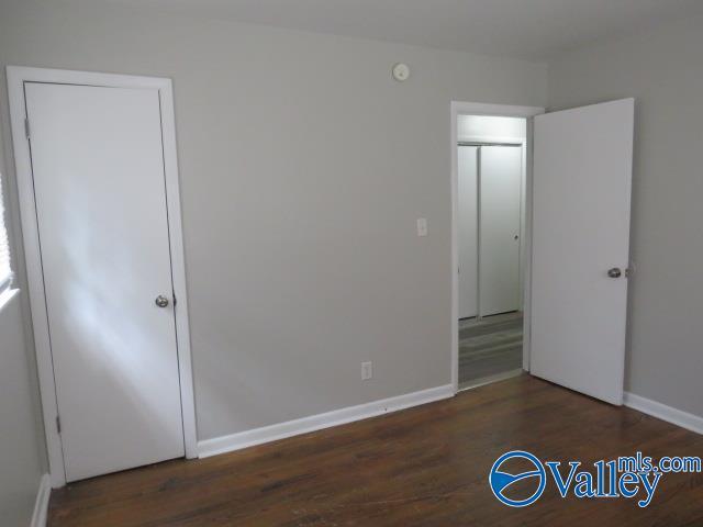 unfurnished bedroom featuring baseboards and wood finished floors