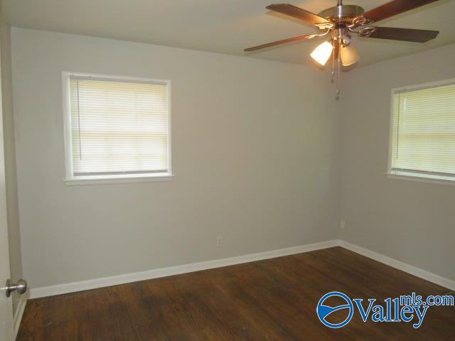 spare room featuring ceiling fan, wood finished floors, and baseboards