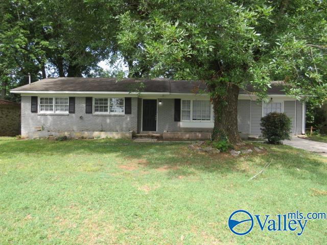 ranch-style home with a garage and a front lawn