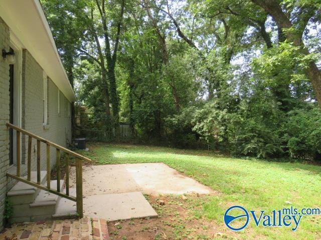 view of yard with central AC unit and a patio area