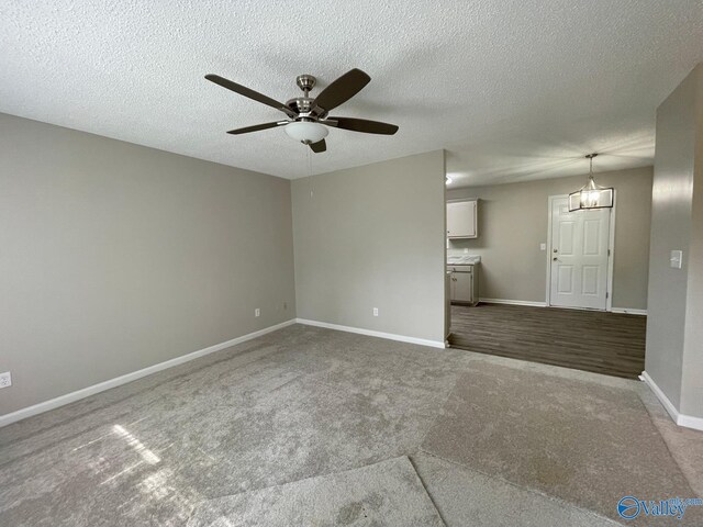 160 Guy Wilson Rd, Hazel Green, AL 35750 - unfurnished living room with a textured ceiling, ceiling fan with notable chandelier, baseboards, and carpet floors