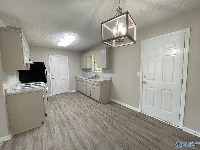 160 Guy Wilson Rd, Hazel Green, AL 35750 - kitchen featuring freestanding refrigerator, light wood-style flooring, a textured ceiling, light countertops, and a sink