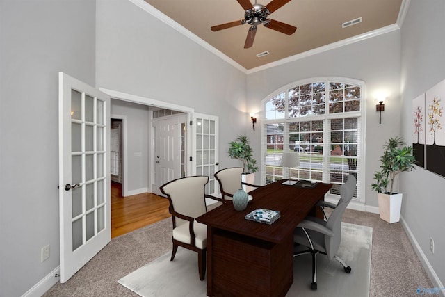 carpeted home office featuring ceiling fan, crown molding, and french doors