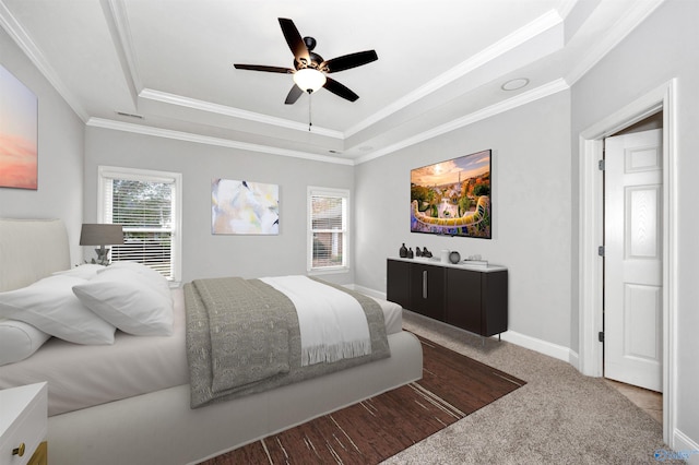 bedroom with a tray ceiling, multiple windows, ceiling fan, and ornamental molding