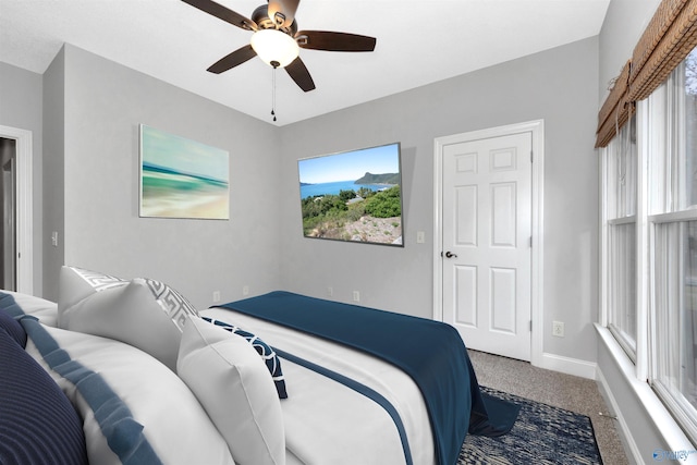 carpeted bedroom featuring multiple windows and ceiling fan