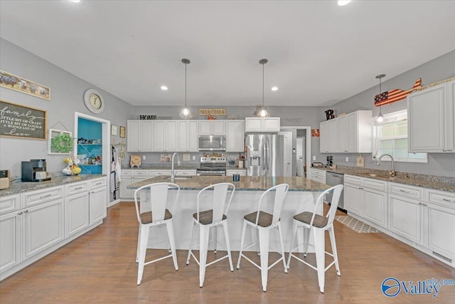 kitchen with appliances with stainless steel finishes, dark wood-style flooring, white cabinets, and a sink